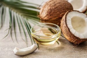 Bowl with coconut oil next to coconuts