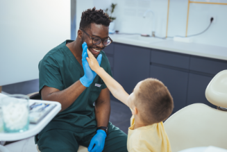 Dentist high fiving a child in dental office 